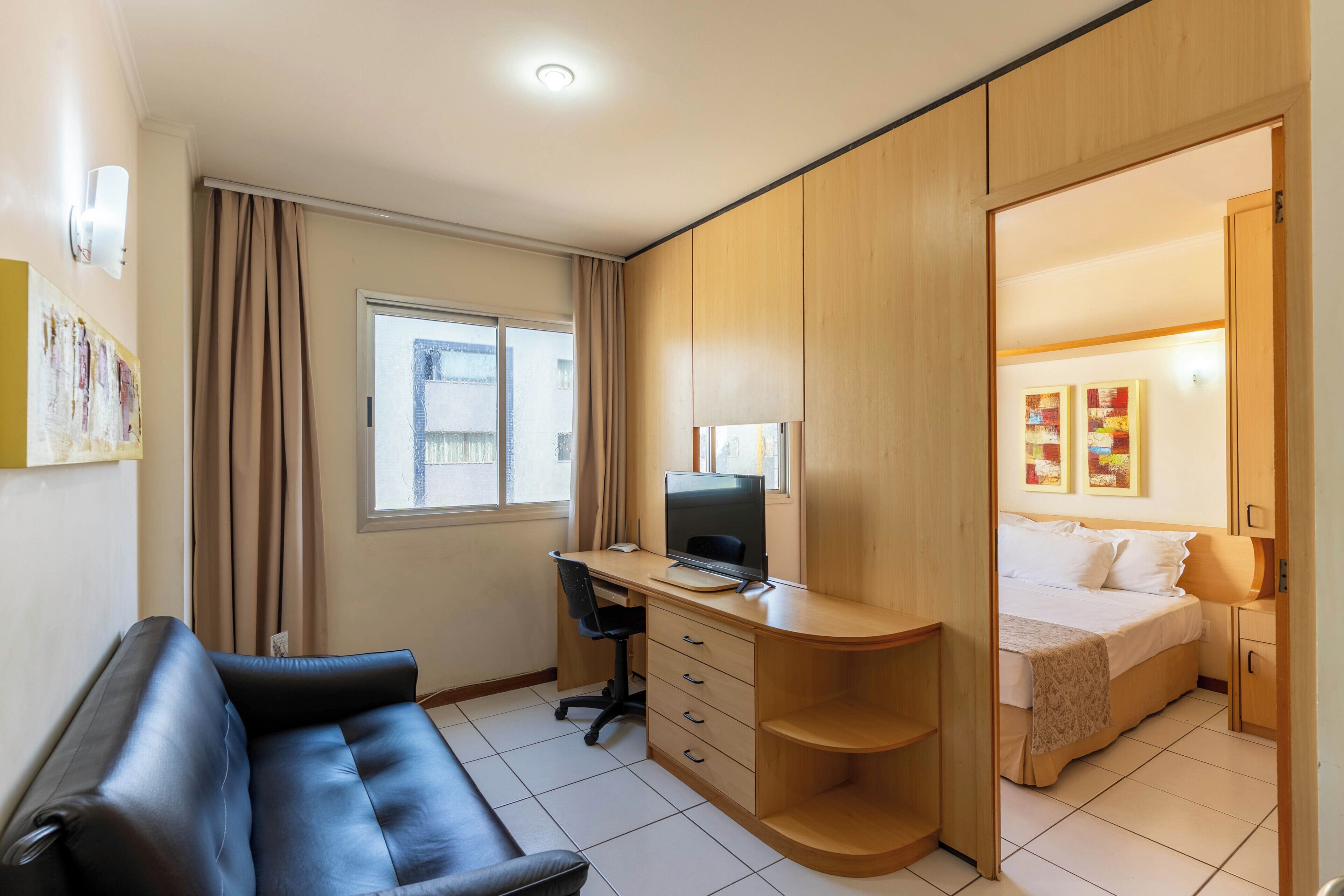 A modern room with a desk, computer, and a bed.