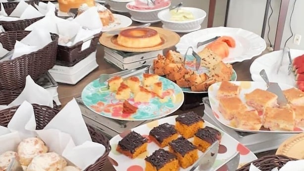 En buffet med forskellige retter, herunder bagværk, sandwiches og desserter.