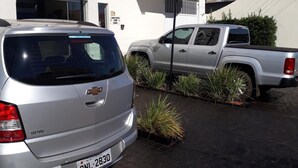 En sølvfarvet Chevrolet Spin holder foran et hotel med skilt for Rota Hotel.