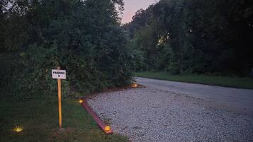 A gravel parking area with a sign indicating parking.