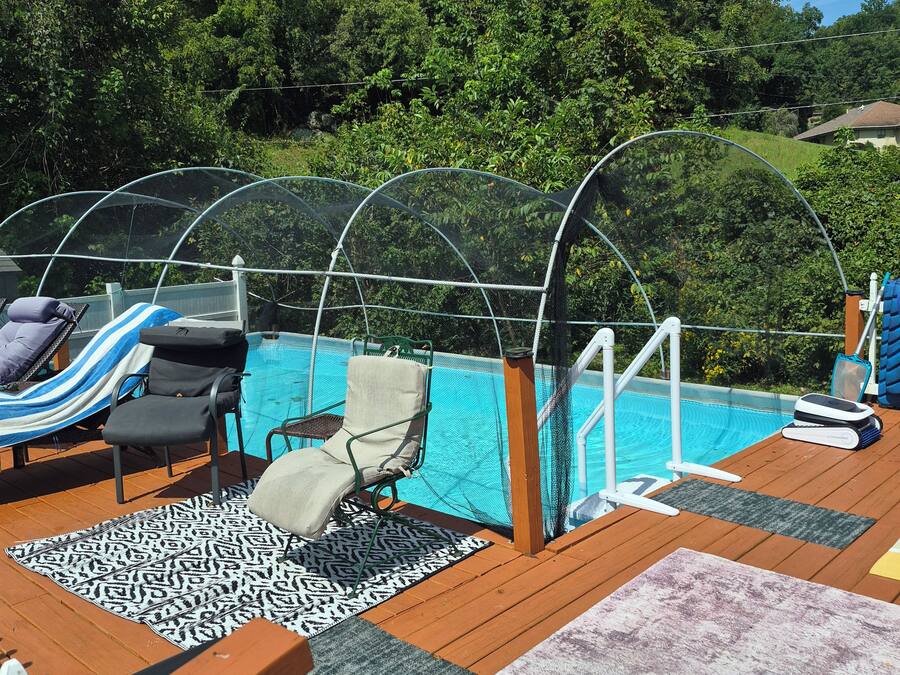 Area piscina con lettini, una zona salotto coperta e un pontile in legno.
