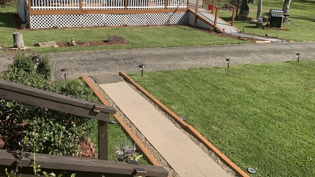 A backyard with a pergola, a wooden deck, and a fenced area with a gazebo. - Log Cabin in the Field (Huntington)