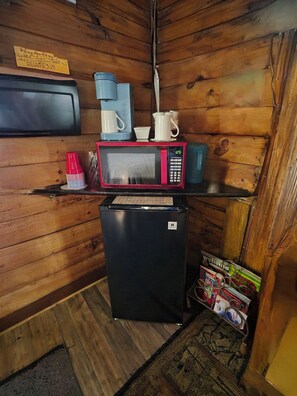 A compact kitchenette with a microwave, coffee maker, and a small refrigerator.