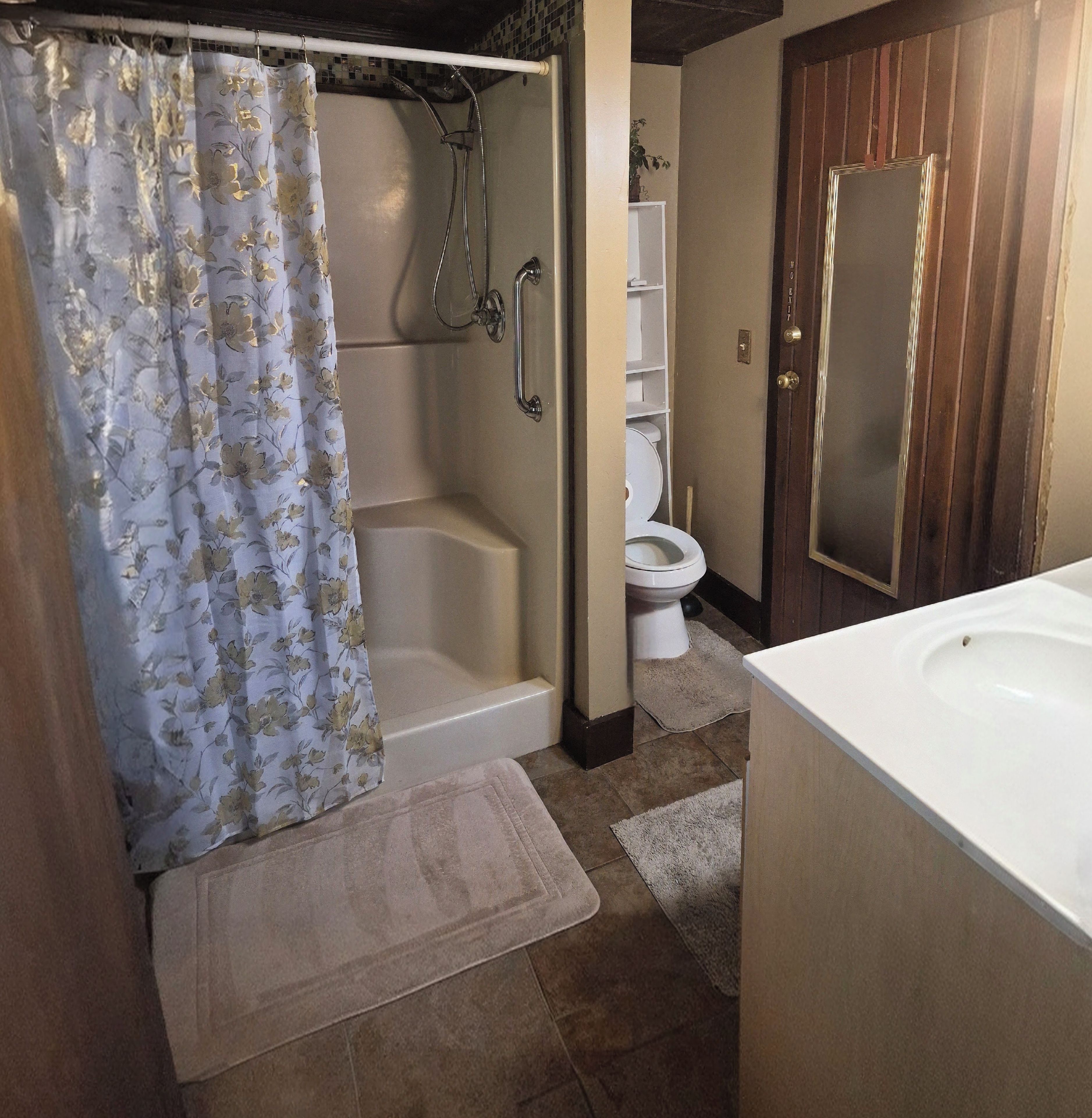 A bathroom with a shower, toilet, and sink.