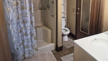 A bathroom with a shower, toilet, and sink.