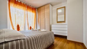 Un dormitorio con cama, cómoda y espejo.