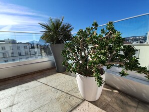 A balcony with potted plants and a view of buildings. - Parco Apartments (Lugano)