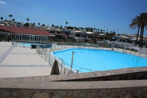 Een buitenzwembad en ligstoelen