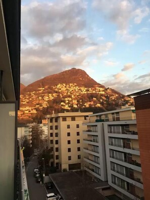 Vista de una montaña con un pueblo a su base, rodeado de edificios modernos.