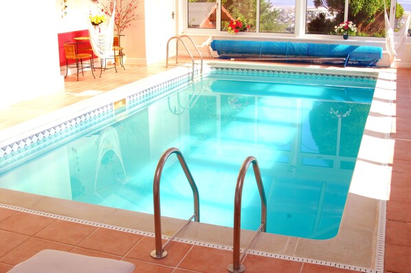 Una piscina cubierta, tumbonas
