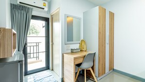 Une chambre moderne avec un bureau en bois, une chaise, un miroir et une armoire.