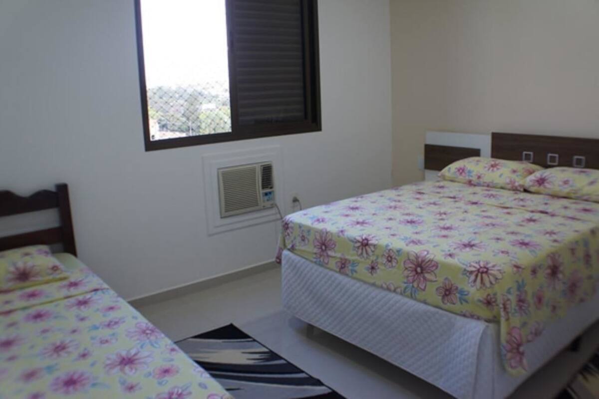 A bedroom with a bed, a window, and a radiator.