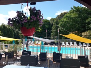 Una piscina al aire libre de temporada, sombrillas