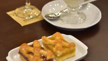 A table with a glass of orange juice, a cup of coffee, and a plate of pastries.