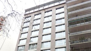 A multi-story building with a modern facade, featuring a prominent entrance with glass doors and a sign that reads "KONKE".