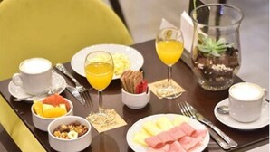 A breakfast setting with a variety of food items and drinks on a table.
