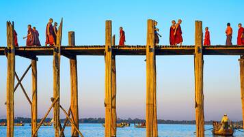 Un puente de madera con monjes vestidos de rojo sobre él.