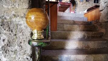 A stone staircase with a wooden handrail and a metal balustrade.