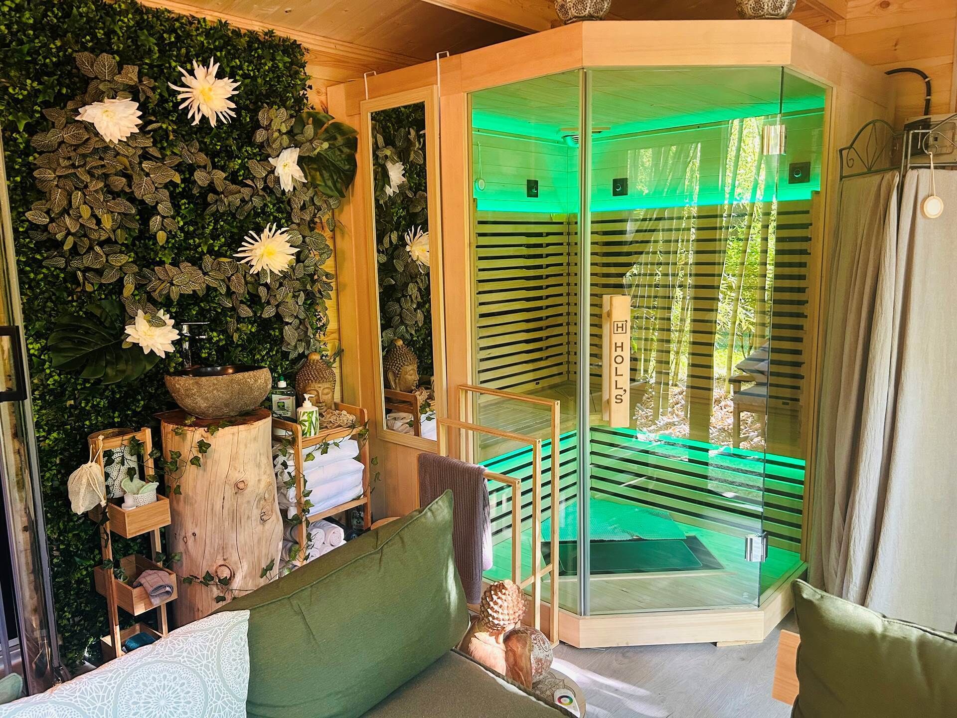Ein modernes Badezimmer mit grüner Wand, einem großen Spiegel und einer Duschkabine aus Glas.