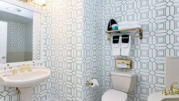 A bathroom with a white sink, a toilet, and a mirror.