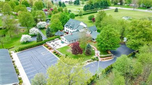 Une grande maison à deux étages, dotée d’un vaste jardin à l’avant, d’une allée et d’un parking.