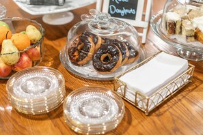 A display of pastries and fruits on a wooden table.