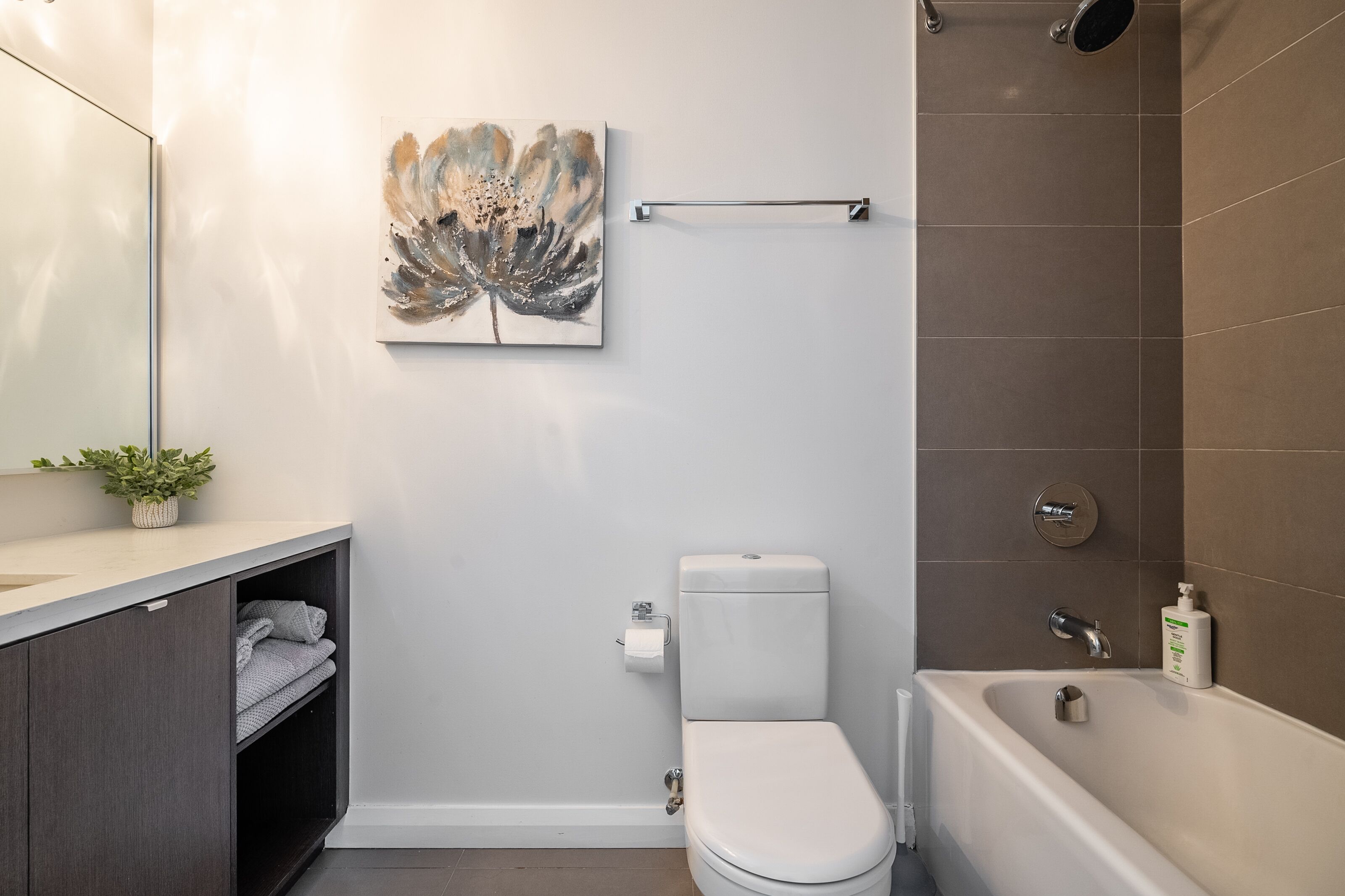 A modern bathroom with a toilet, sink, and bathtub.