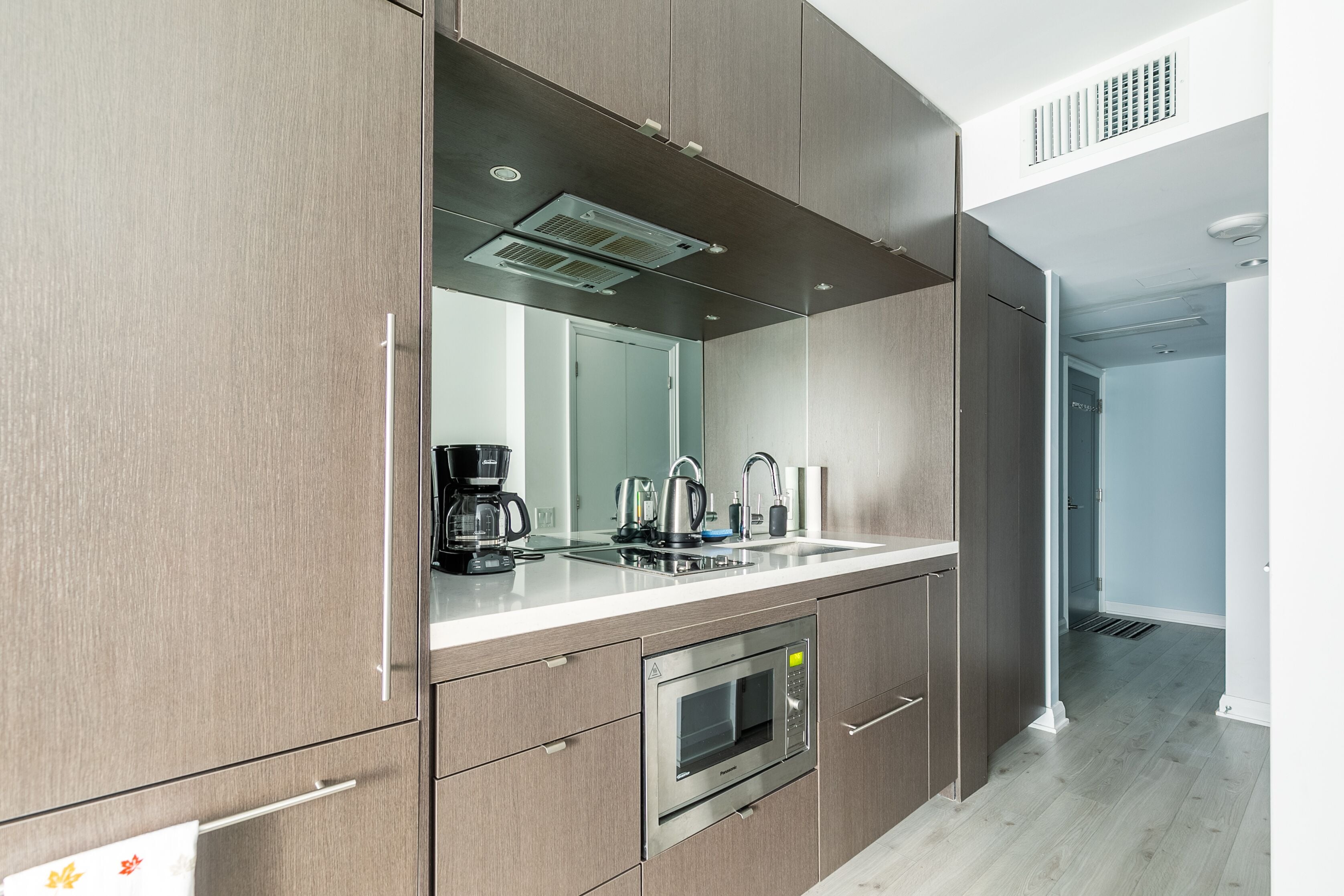 A modern kitchen with a built-in microwave, oven, and sink.
