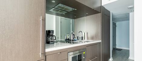 A modern kitchen with a built-in microwave, oven, and sink.