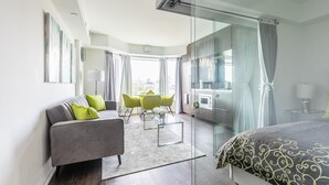 Ett modernt hotellrum med en säng, en soffa, en matplats och utsikt över staden.