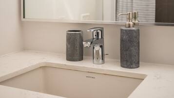 A bathroom with a white sink, a mirror, and a shower curtain.