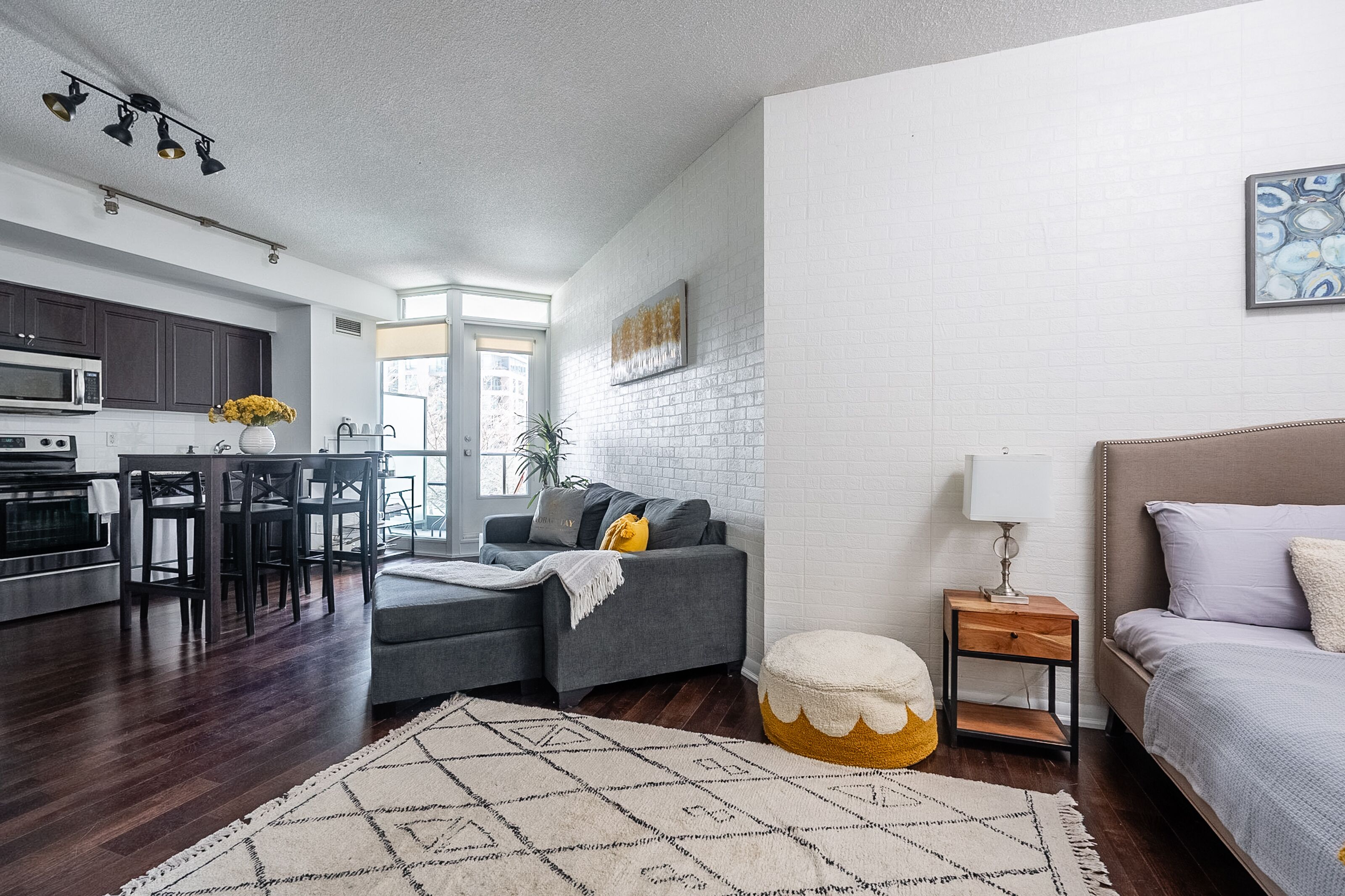 A modern living space with a kitchen, dining area, and a bedroom.