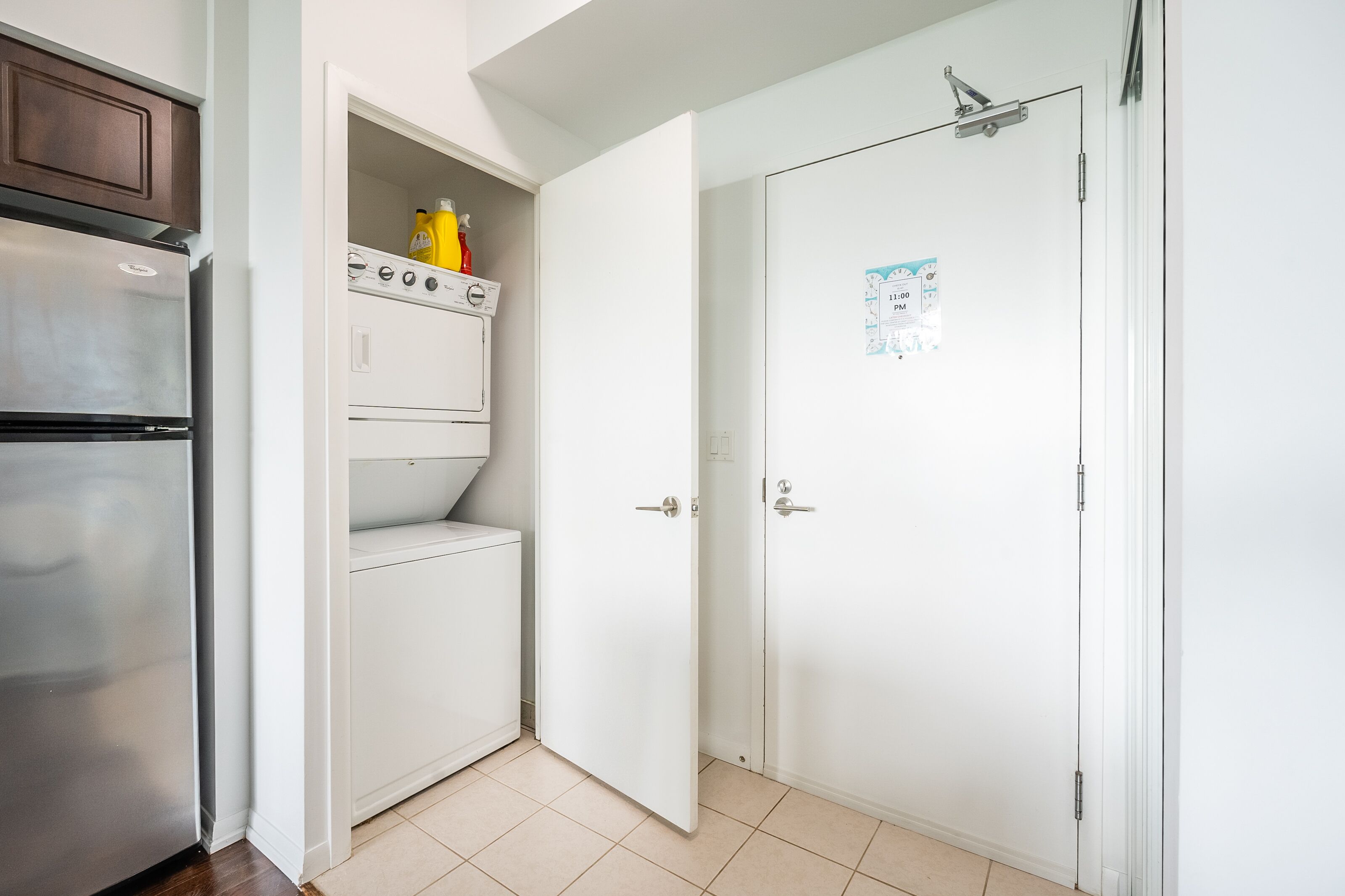 A compact kitchen with a refrigerator, oven, and washing machine.