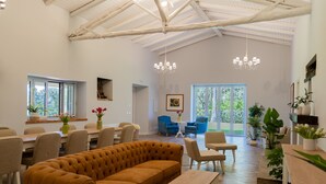 A spacious living area with a high ceiling, a large sofa, dining table, chairs, and a chandelier. - Villa Cammà (Mirto)