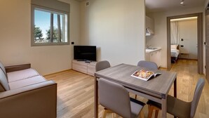 Un salon moderne avec un canapé, une table à manger et un téléviseur.