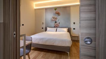 Una camera da letto moderna con un letto, comodini, una sedia e un'opera d'arte appesa al muro.