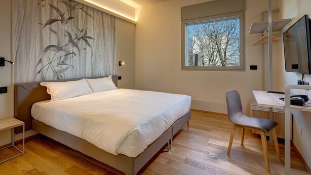 Une chambre moderne avec un grand lit, un bureau et une chaise.