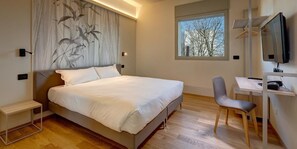 Une chambre moderne avec un grand lit, un bureau et une chaise.
