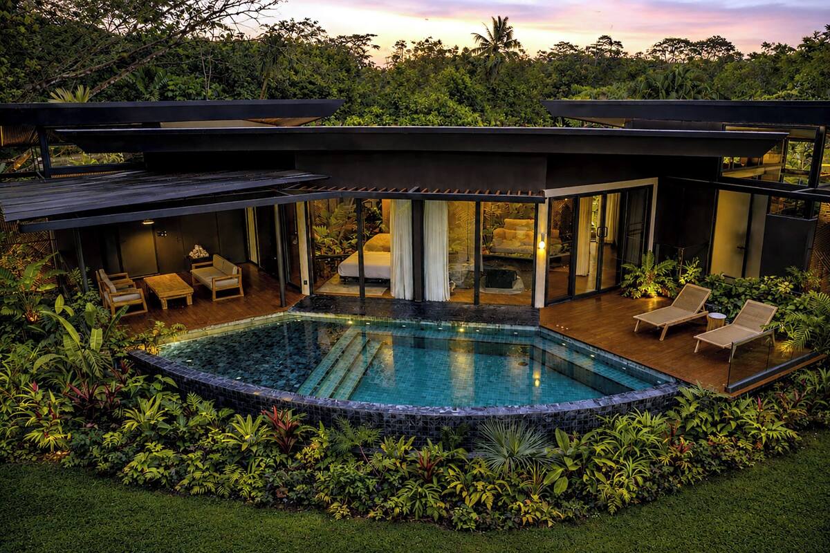 A modern house with a swimming pool, outdoor seating, and lush greenery.