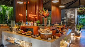 A buffet area with a variety of food items, a coffee station, and a glass display case.