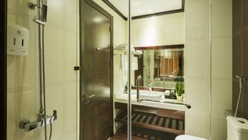 A modern bathroom with a glass shower enclosure, a sink, and a toilet.