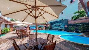 A wooden deck with outdoor seating and a pool.