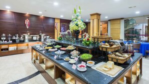 A buffet setup with various food items and a central floral arrangement.