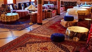 A traditional room with a high ceiling, ornate columns, and patterned rugs. - Hotel Boutaghrar (Ighil N'Oumgoun)