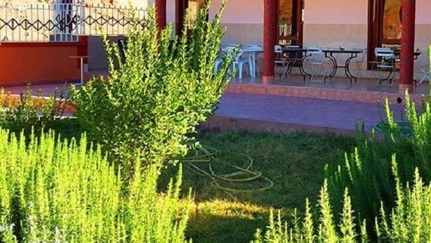 A hotel cafe with outdoor seating and a garden area. - Hotel Boutaghrar (Ighil N'Oumgoun)