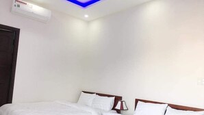 A hotel room with two beds, a ceiling light, and an air conditioning unit. - Motel Thanh Long (Da Nang)