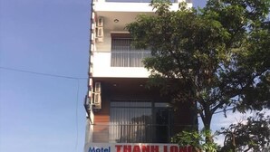 A two-story building with a sign for 'Motel Thanh Long' at the entrance. - Motel Thanh Long (Da Nang)
