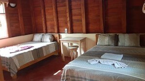 Una habitación con una cama, un pequeño escritorio y un banco.