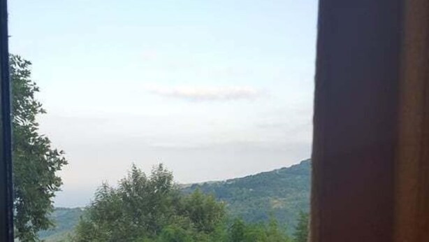 A patio with a round table and a bench, overlooking a mountainous landscape. - Victoria's Country Apartments (Zagora-Mouresi)