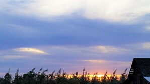 Un atardecer con cielo despejado y la silueta de un edificio.